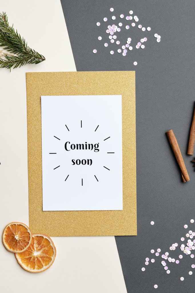 A festive holiday-themed flat lay featuring a 'Coming Soon' greeting card with decorative elements.